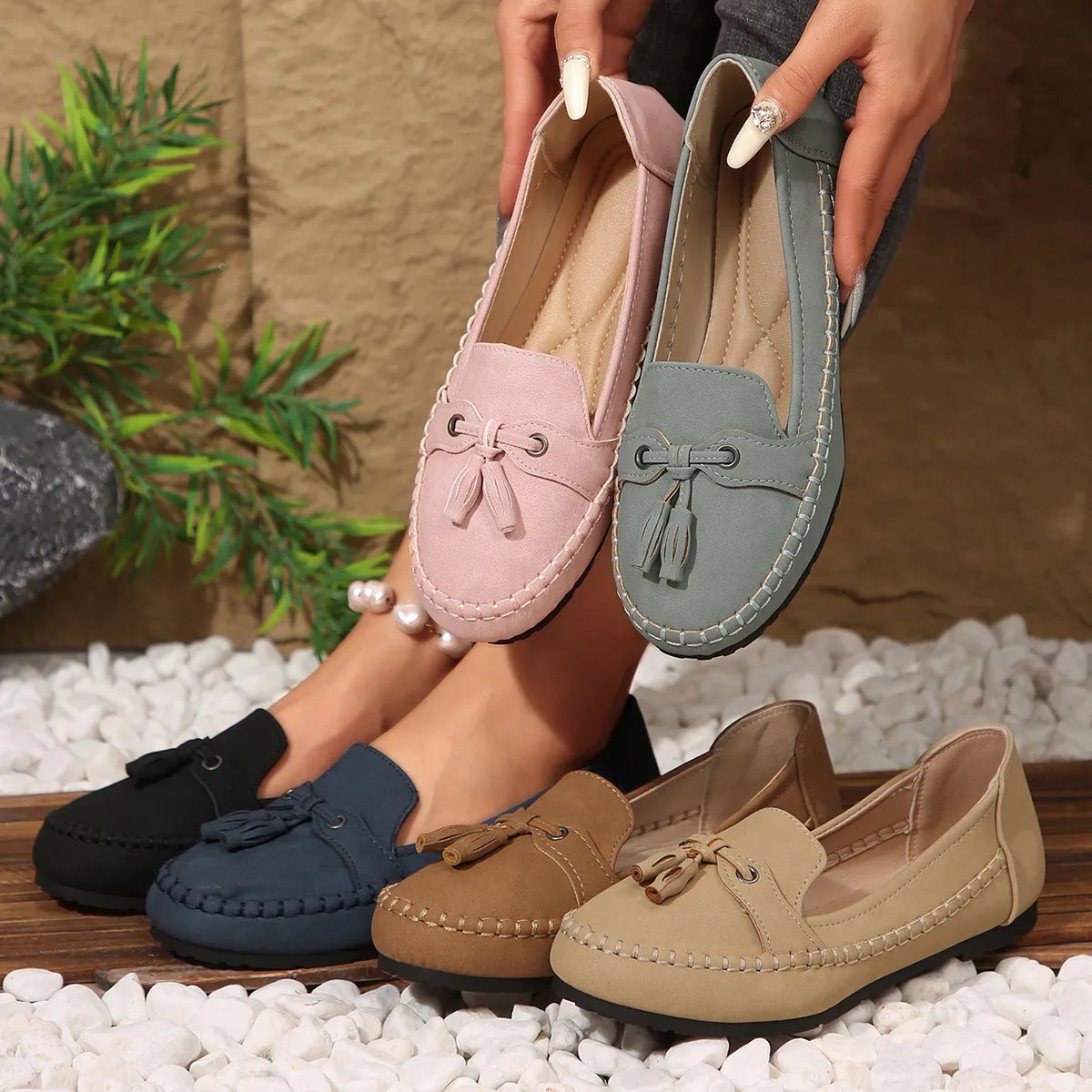 Tassel-trimmed suede loafer flats in pink, gray, black, navy, tan, and terracotta.