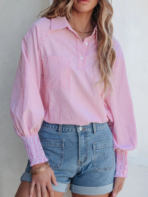 Pink striped collared shirt with balloon sleeves and smocked cuffs, paired with denim shorts.