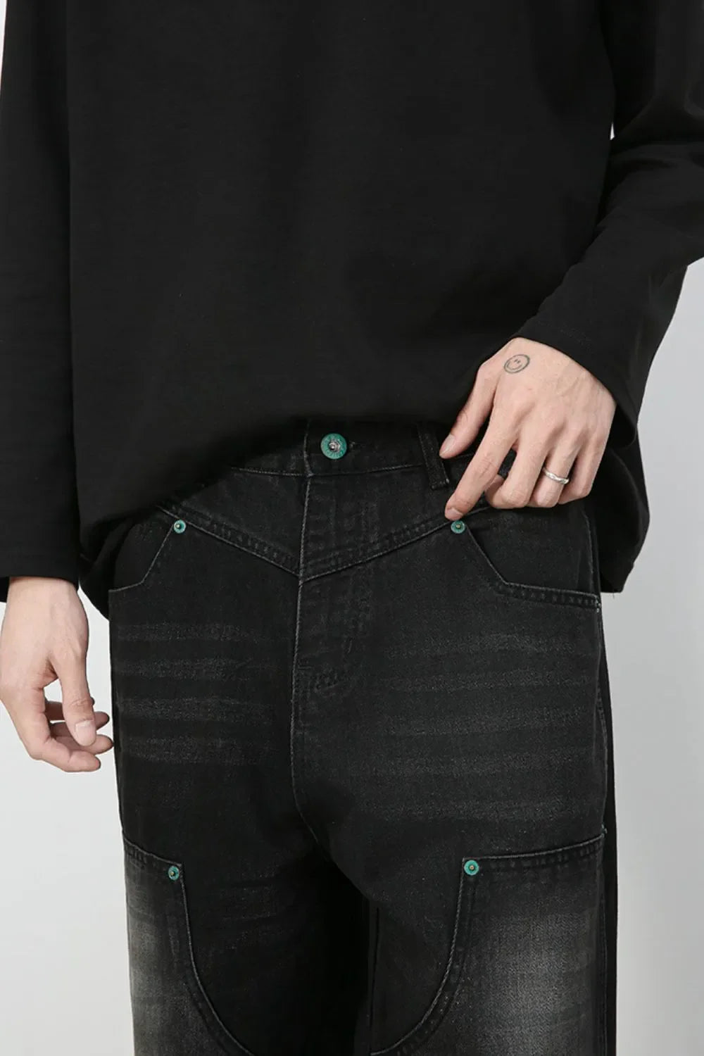 Faded wash dark wide-leg carpenter jeans with teal button details.