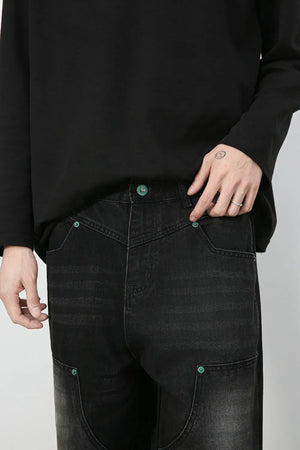 Faded wash dark wide-leg carpenter jeans with teal button details.