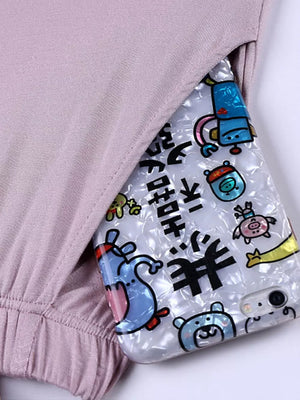 Relaxed padded tank top in Bean Paste Powder with a pocket detail revealing a phone case with cartoon characters.