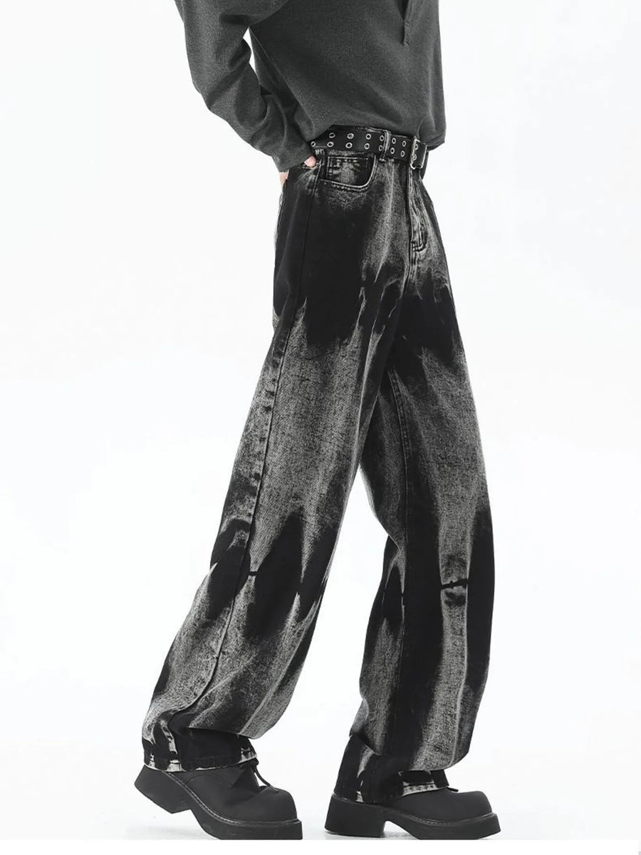 Men's black relaxed fit jeans with acid wash detail and studded belt.