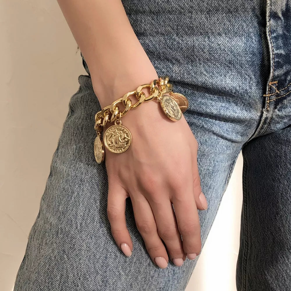 Chunky gold-plated coin charm bracelet with a bold curb chain and adjustable clasp.