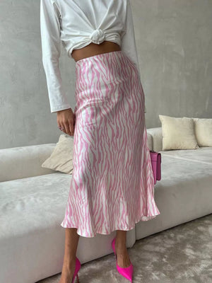Satin midi skirt with pink and white zebra print, bias cut, and slight flare hem.