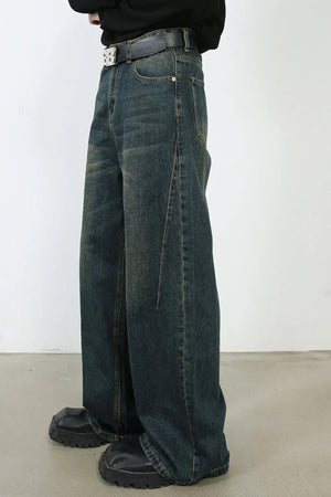 Faded dark denim wide-leg trousers with a relaxed fit and visible stitching detail.