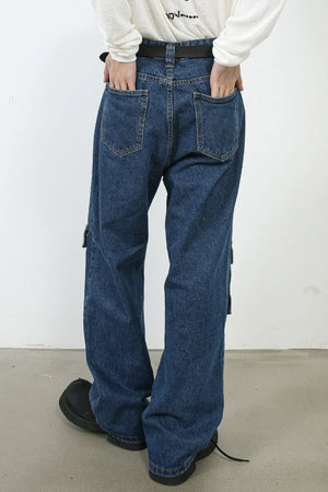 Medium wash denim cargo pants with buckle pocket detail and wide leg cut.