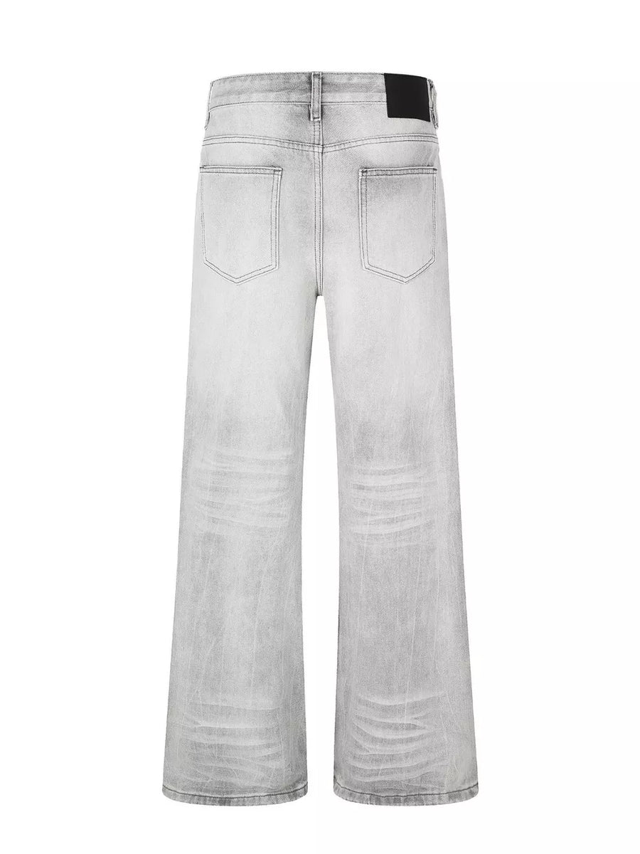 Men's gray vintage wash wide leg jeans with distressed details.
