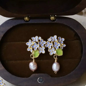 Floral pearl drop earrings with light blue flowers and pink pearls.