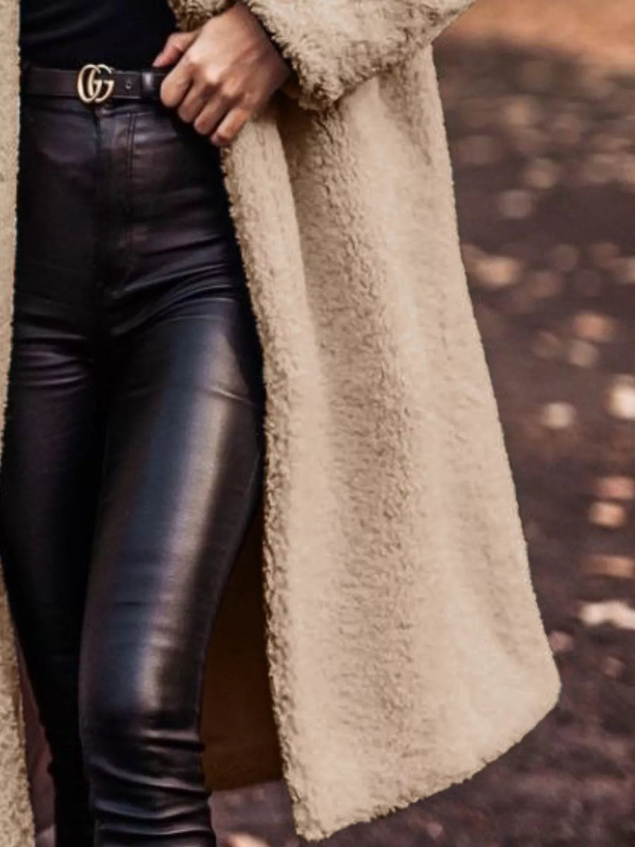 Longline teddy bear coat in camel, open front, worn with black leather pants.