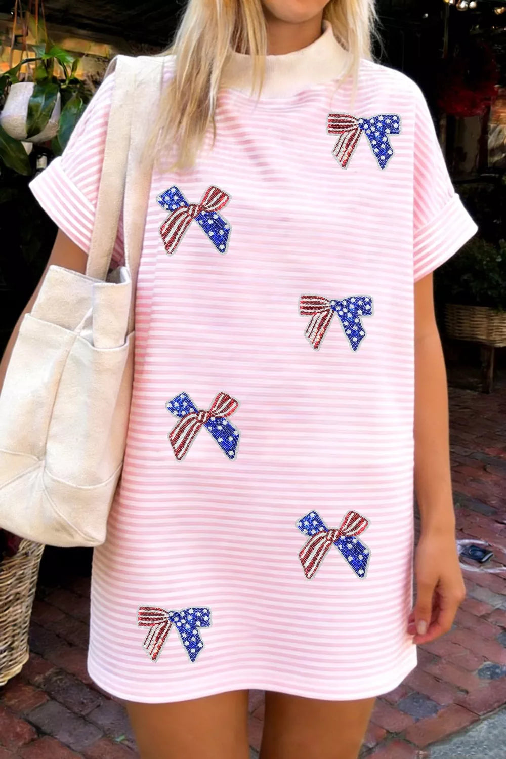 Pink striped mini dress with American flag bow embellishments and a mock neck.