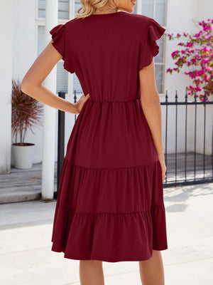 Burgundy ruffled midi dress with tiered skirt and flutter sleeves.