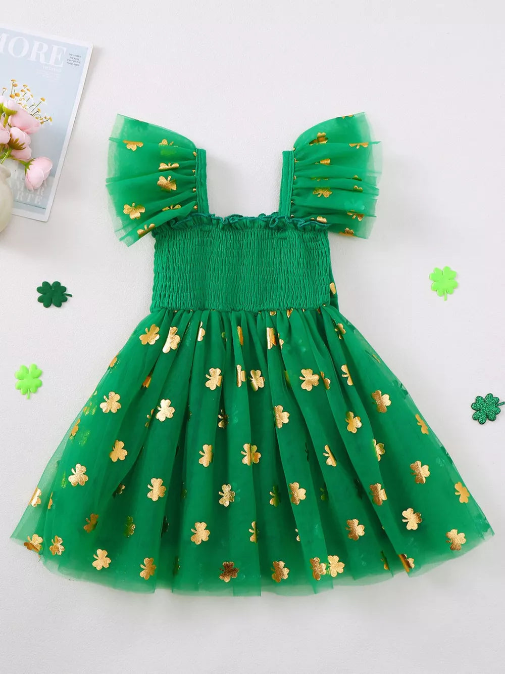 Green tulle dress with gold shamrock print, smocked bodice, and flutter sleeves.