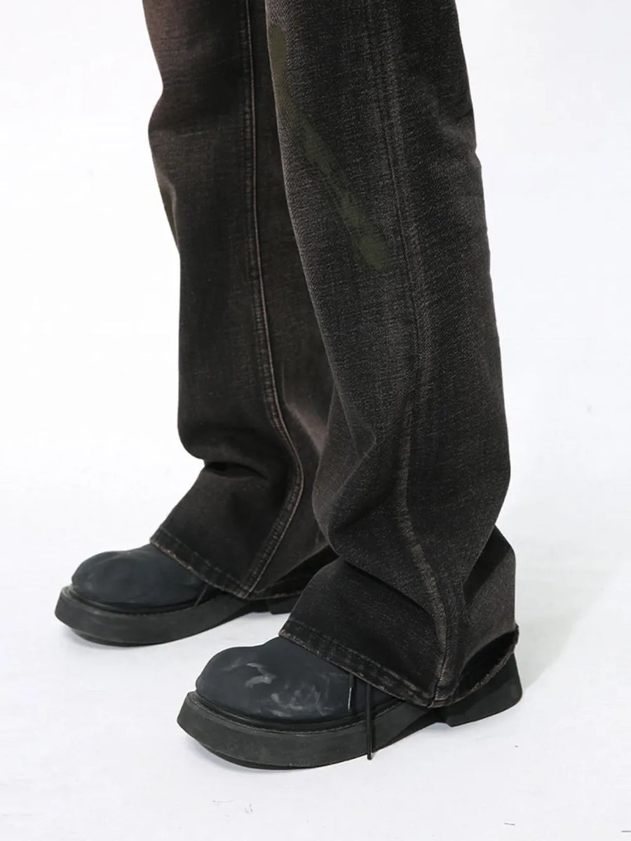 Dark wash bootcut jeans with a faded effect and a slight flare, styled with chunky black shoes.