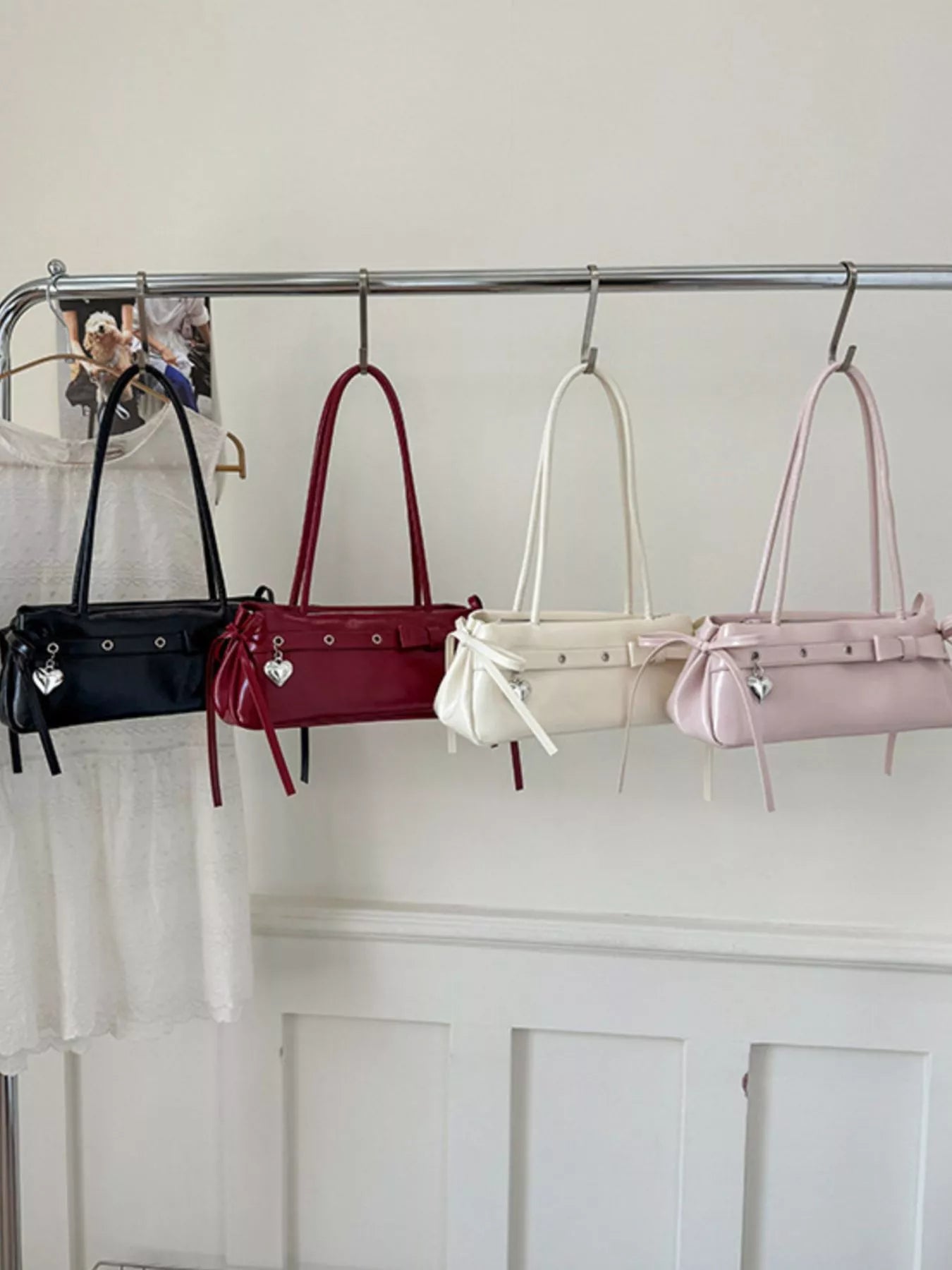 Chic PU leather shoulder bags in black, red, white, and pink with heart charms.
