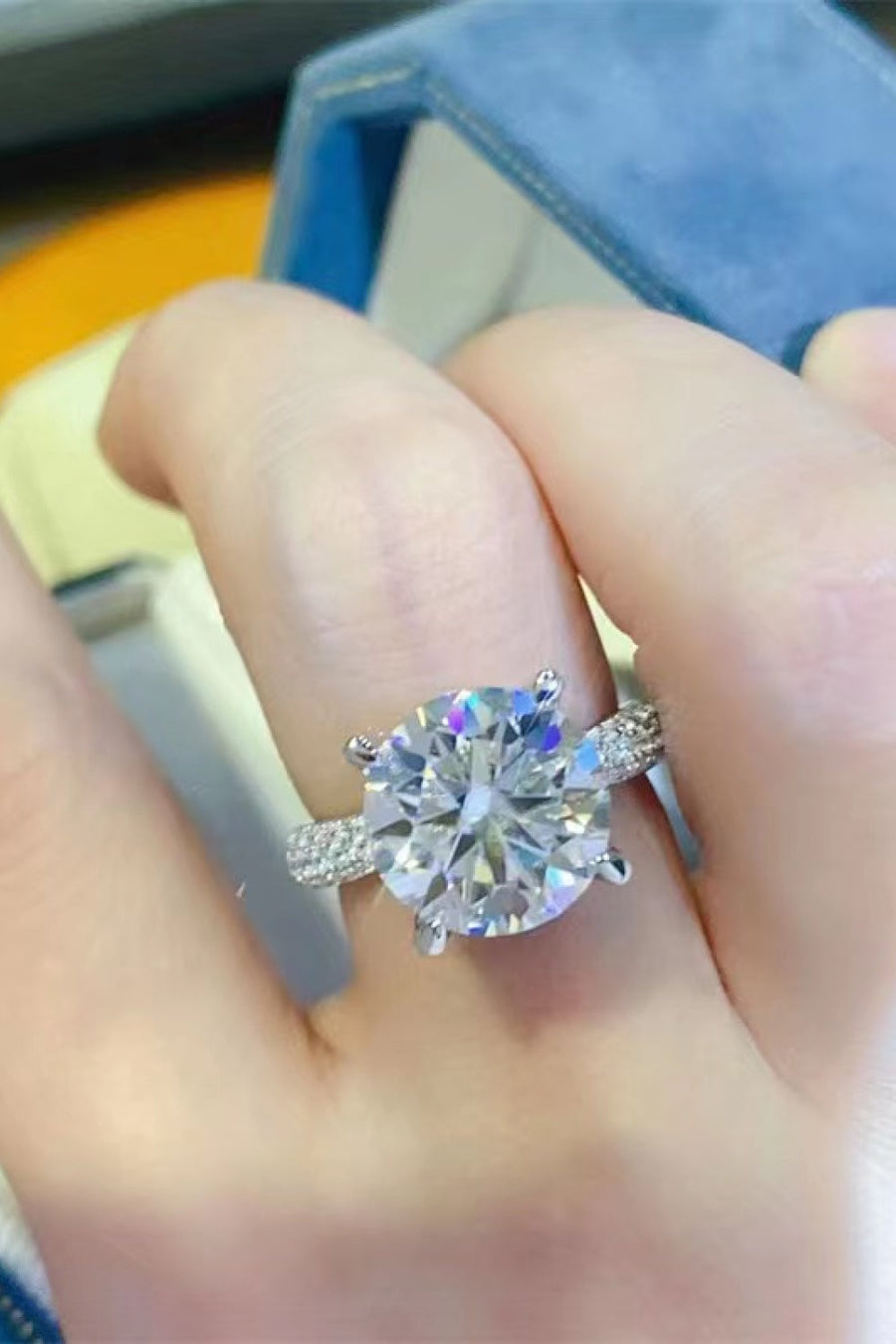 Silver pavé band round moissanite solitaire ring with a large center stone.