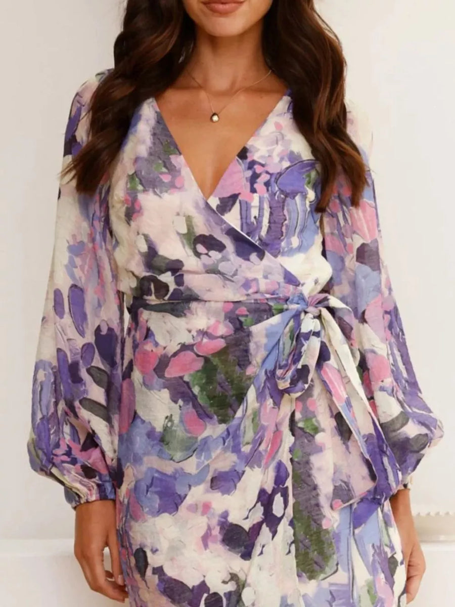 V-neck tie waist dress with abstract floral print in purple and pink, featuring balloon sleeves.