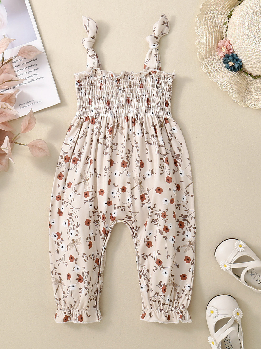 Floral print baby jumpsuit with smocked bodice and tie straps.