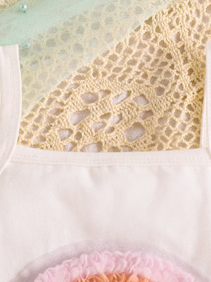 White cotton baby top with pastel rainbow applique and lace trim.