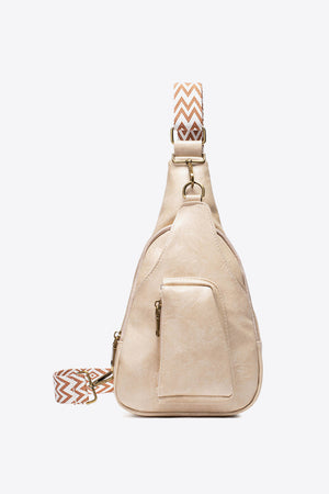 Beige textured sling bag with woven strap detail and front pocket