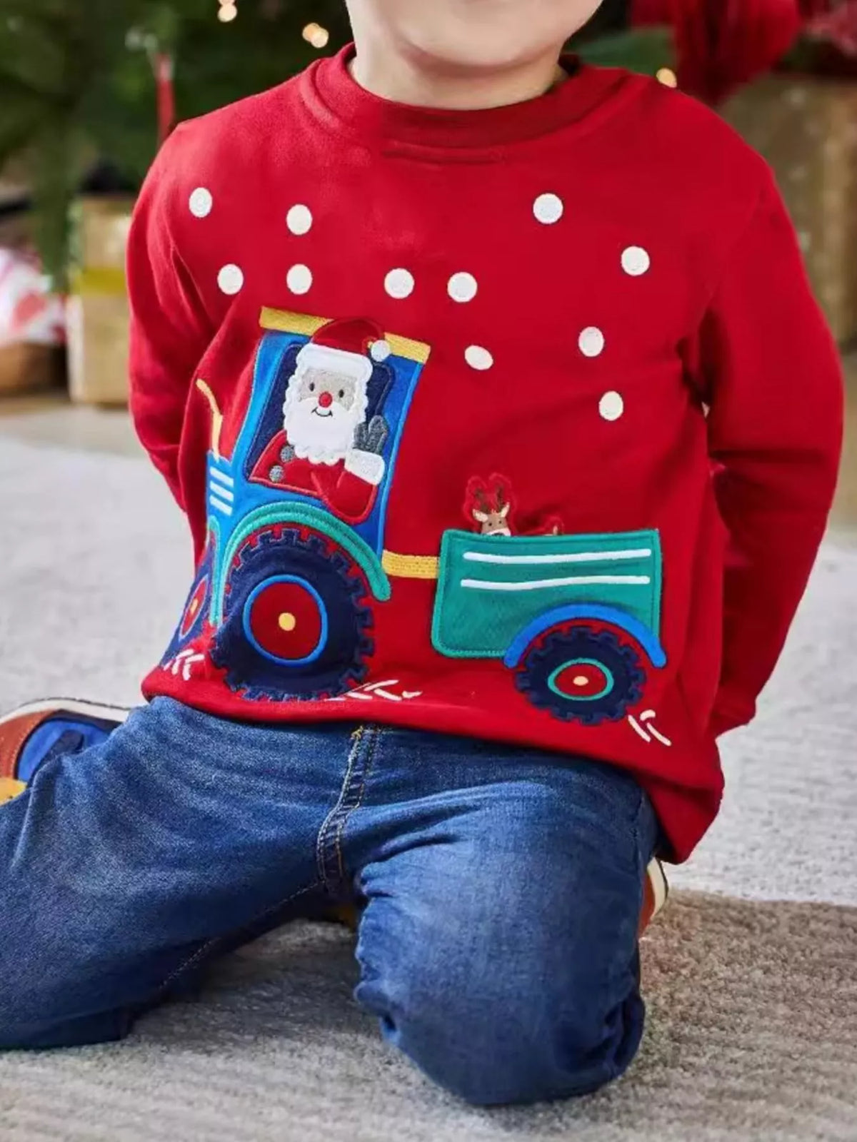 Red crew neck sweatshirt with Santa in a tractor applique and white polka dots.