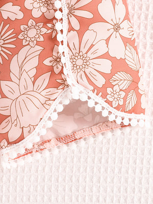 Light brown floral baby shorts with white pom-pom trim