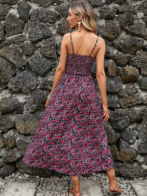 Midi dress with smocked bodice, spaghetti straps, and a black floral print.