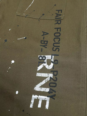 Olive green cotton cargo pants with white paint splatters and bold black text.