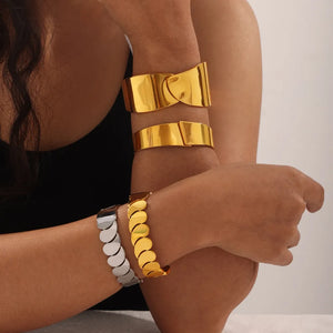 Gold leaf cuff bracelets and scalloped bracelets in gold and silver tones.