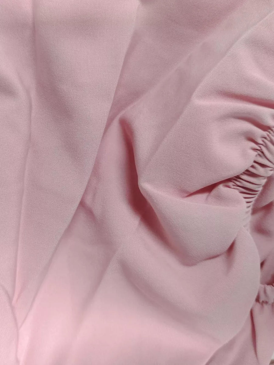 Pink midi dress with puff sleeves and tie front detail.