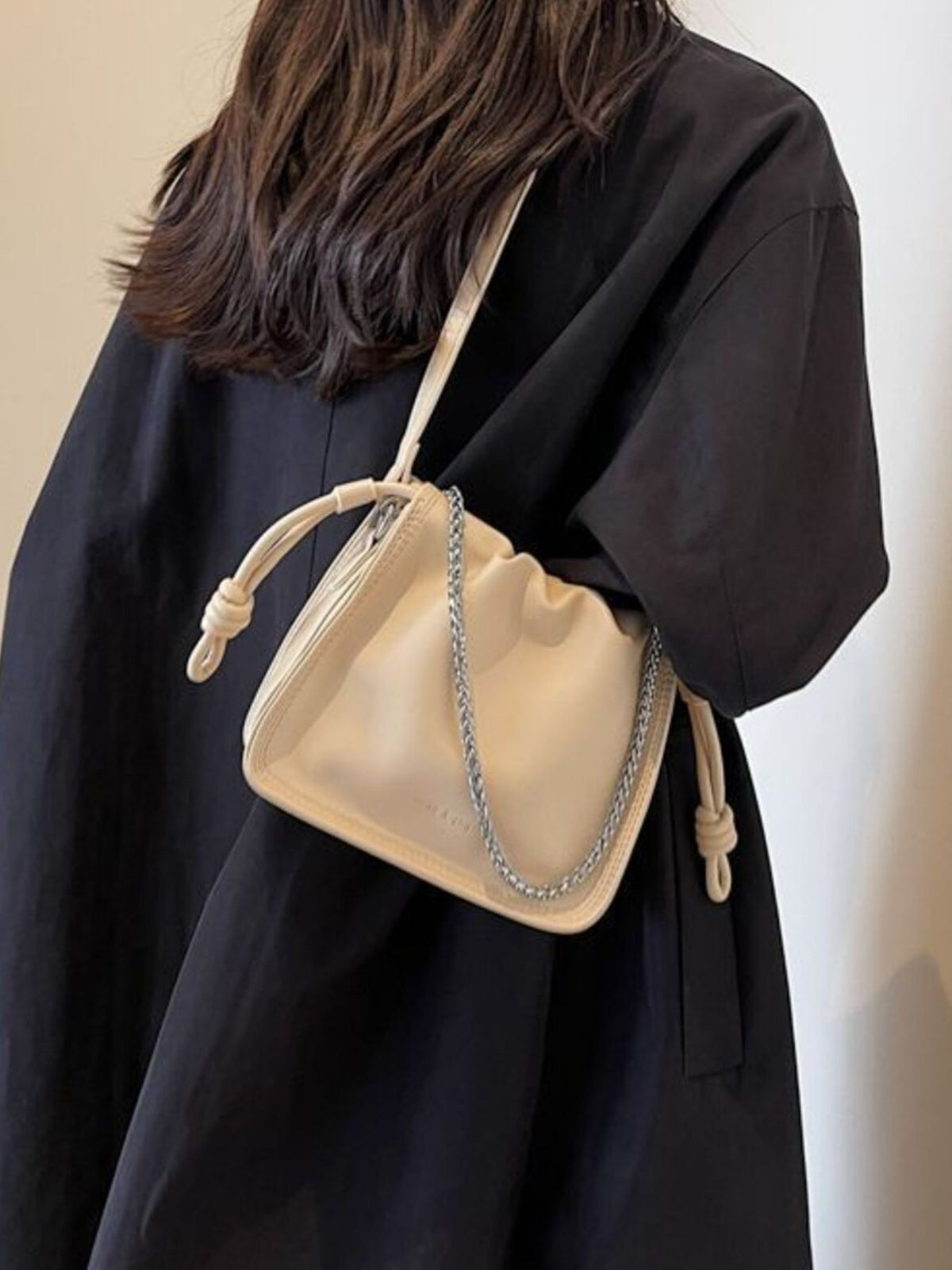 Off-white ruched PU leather crossbody bag with chain detail and knotted strap