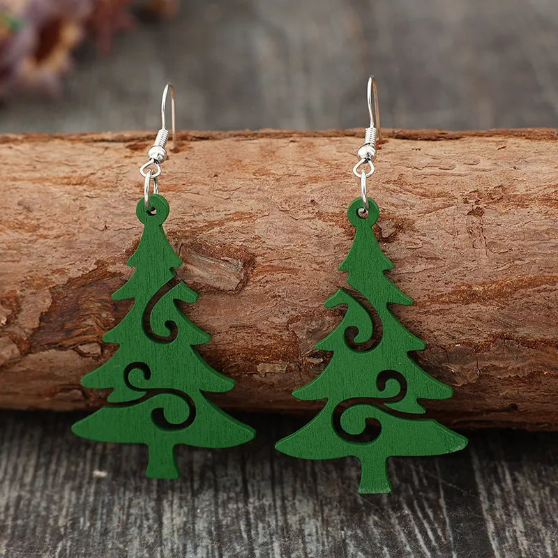Green carved Christmas tree earrings with swirl details.