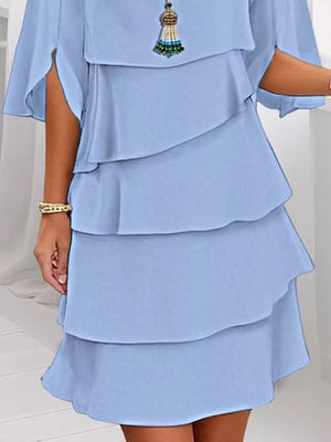 Light blue ruffled layered flutter sleeve dress with tiered skirt and tassel necklace.