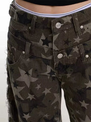 Distressed wide-leg jeans with a dark star print and raw hem detail.
