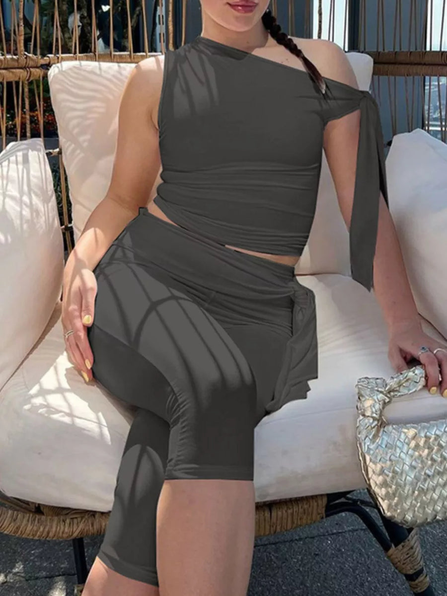 Sculpted asymmetrical top and capri set with tie detail in dark grey.