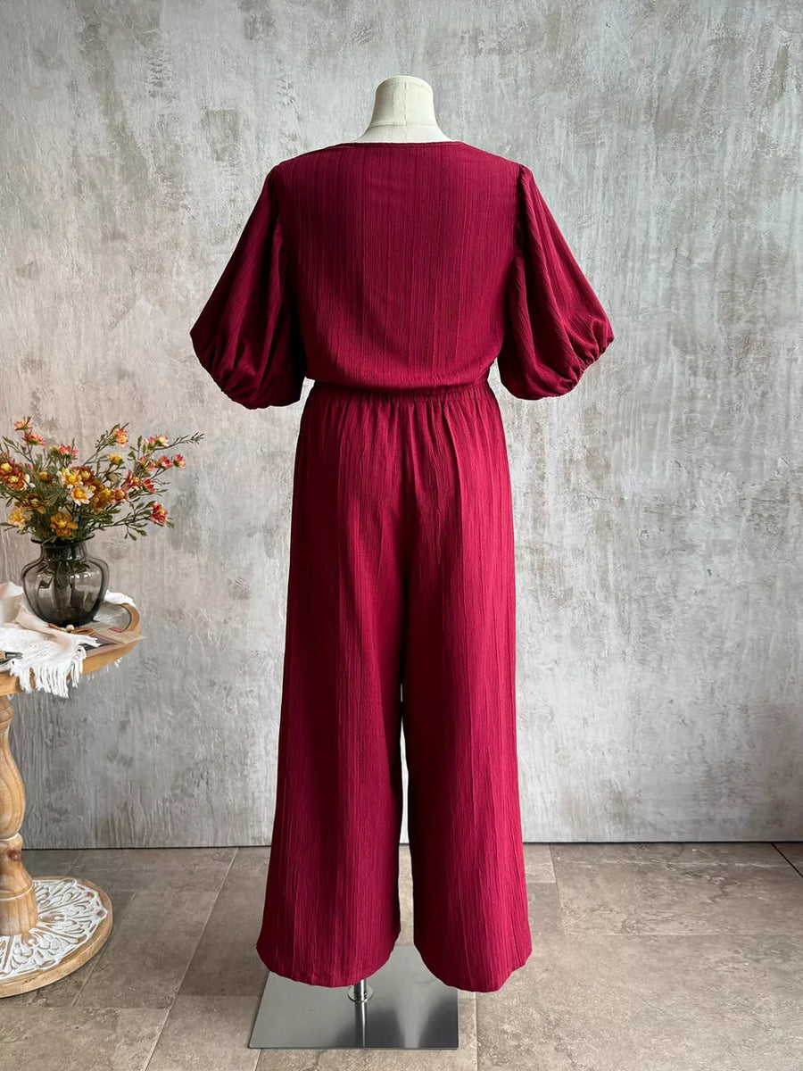 Deep red textured tie-front crop top with balloon sleeves and wide-leg pants set.