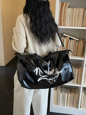 Sleek black PU leather travel bag with white script logo and top handles.