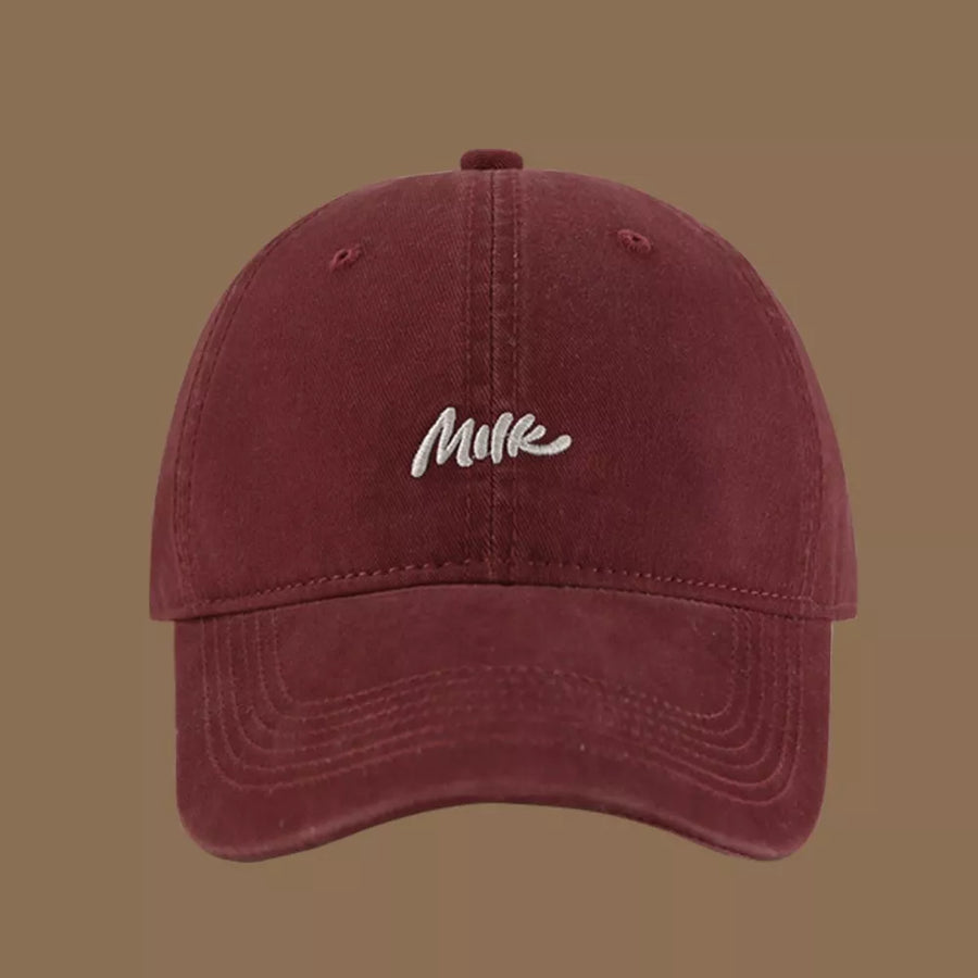Wine red baseball cap with embroidered "Milk" text detail