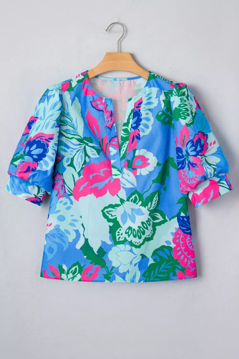 Vibrant floral v-neck blouse with relaxed fit and puff sleeves.