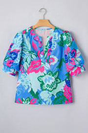 Vibrant floral v-neck blouse with relaxed fit and puff sleeves.