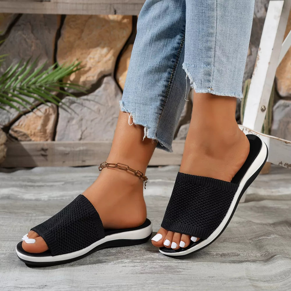 Chic black open-toe knit slide sandals with white sole and mid-heel.