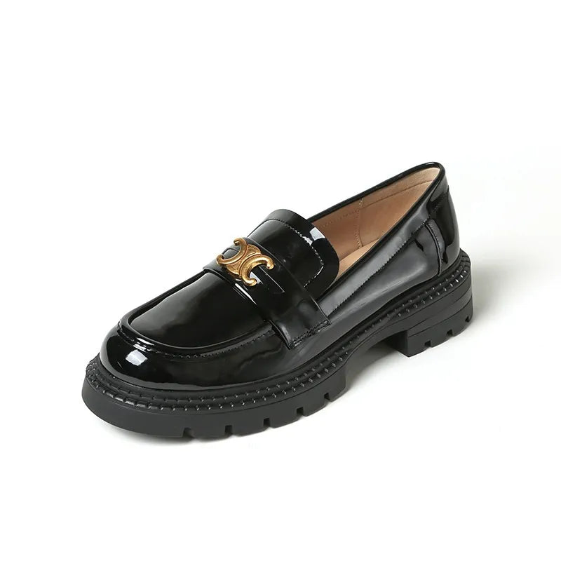 Black patent leather loafers with chunky sole and gold buckle detail.