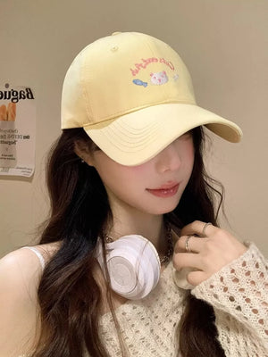 Yellow baseball cap with embroidered cat and fish graphic, adjustable strap, and curved brim.
