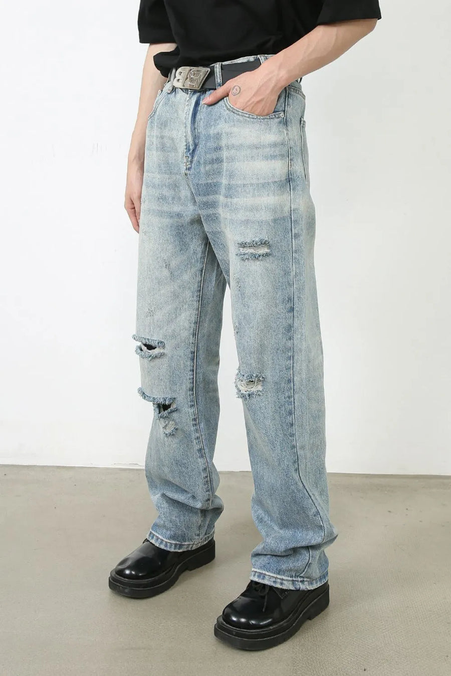 Baggy light wash denim jeans with distressed rips and a modern fit.