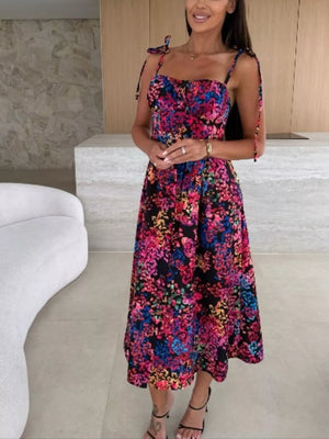 Floral tie-strap midi dress with a vibrant multi-color floral print on black.