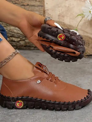 Brown faux leather loafers with stitched sole and laces.