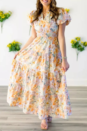 Vibrant floral smocked maxi dress with tiered skirt and short flutter sleeves.