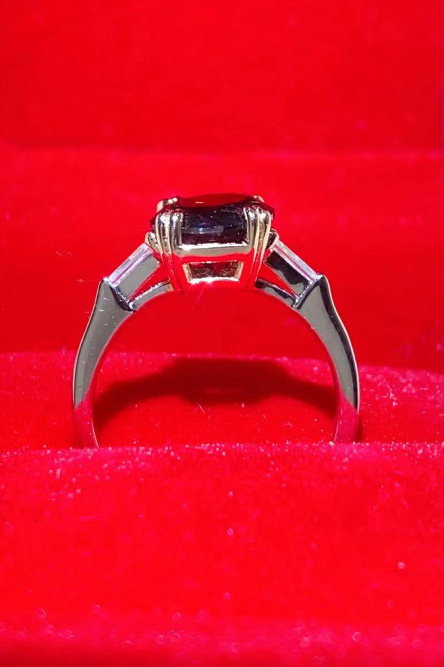 Black moissanite solitaire ring with baguette accents in sterling silver.