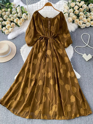 Brown chiffon maxi dress with floral embroidery, belted waist, and button-down front.
