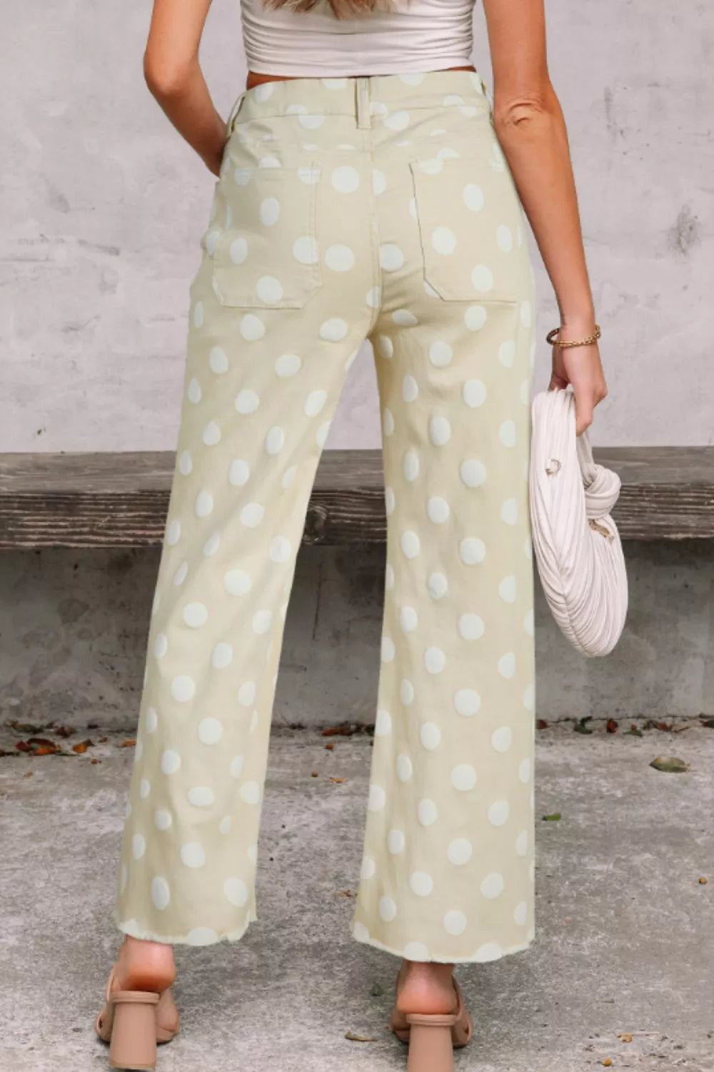 Polka dot high-waisted wide-leg jeans in light yellow denim with white polka dots.