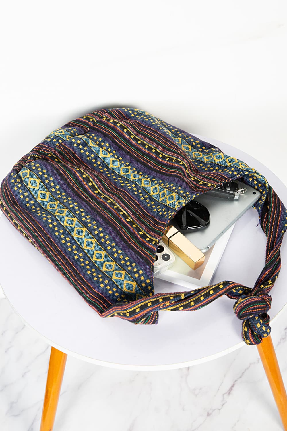 Tribal weave shoulder bag in multicolor with diamond pattern, canvas material, and knotted strap.